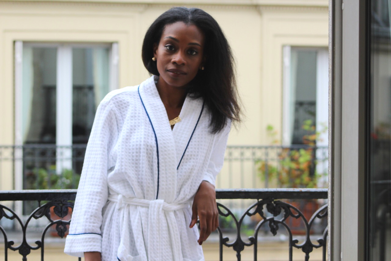 young woman on balcony in paris france after winter skincare routine